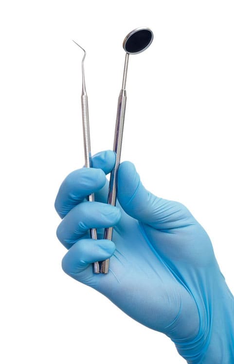 рука в голубой стоматологический перчатке держащая стоматологический инструмент