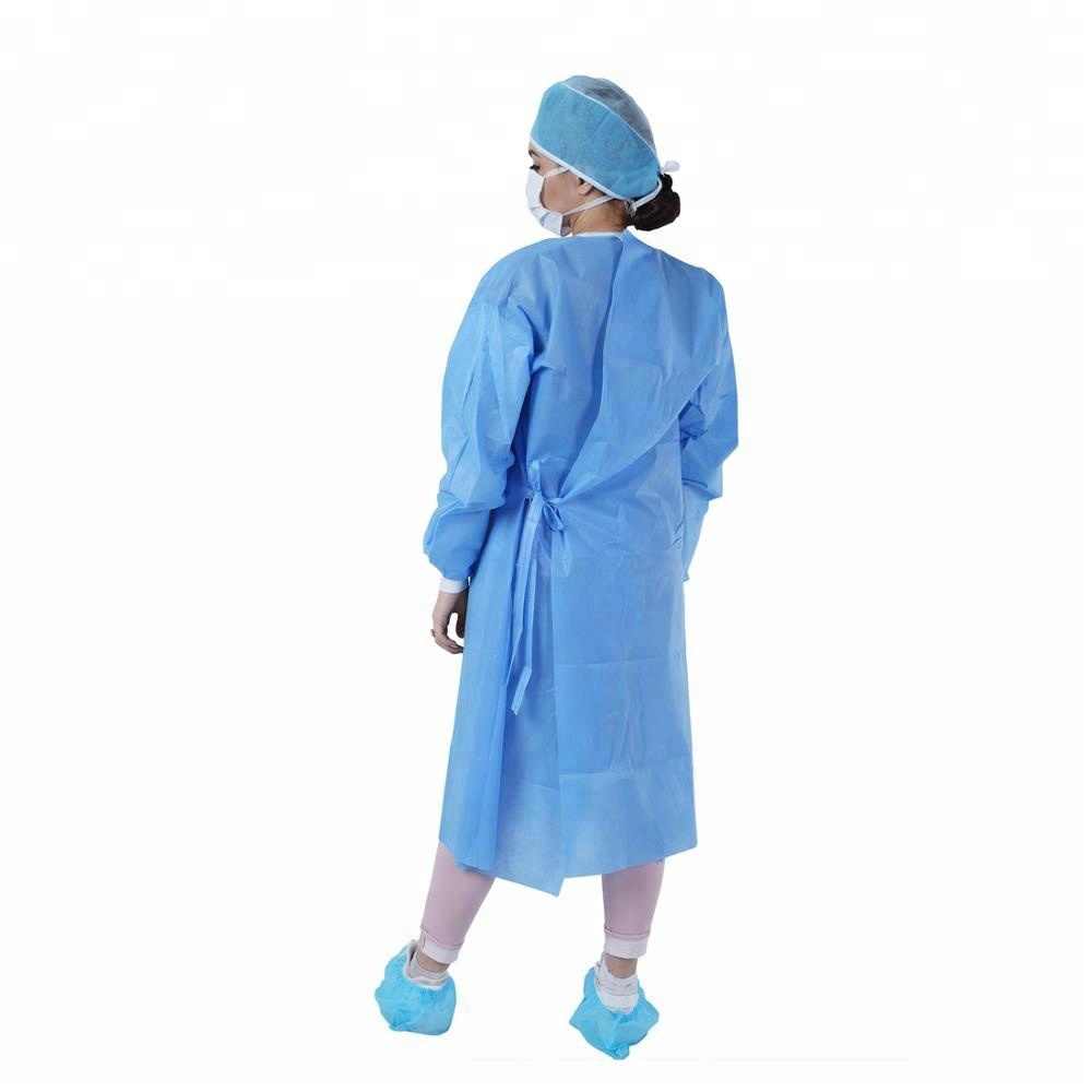 комбинезон хирургический халат демонстрирует женщина в полоборота вид сзади, на ногах обувь в бахилах, на лице защитная маска, на голове защитный платок.